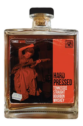 Bottle of Hard Pressed Tennessee Straight Bourbon Whiskey with a label featuring a woman playing guitar.