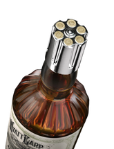 Bottle cap with bullet design on a bottle labeled 'Watt & Warp' against a black background