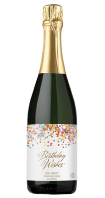 Bottle of 'Birthday Wishes' sparkling wine with a glass of champagne on a white background