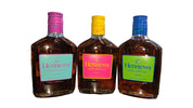 Three Hennessy bottles with colorful caps on a desk with a blurred background