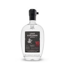 A bottle of Torola 10 Year Old Mezcal by Lost Explorer on a clean white background. The clear glass bottle features a black cap and a black label with white and red text.