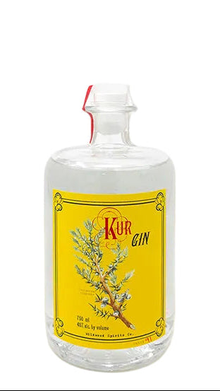 Bottle of Kuh Gin with a yellow label on a white background