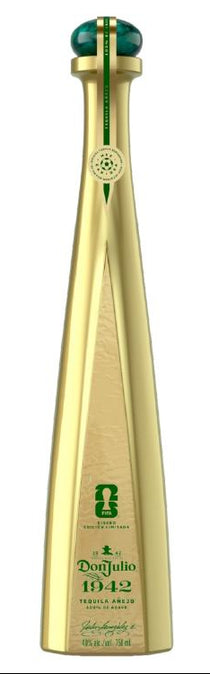 Two gold bottles and two green boxes of Doñ Julio 1942 on a white background